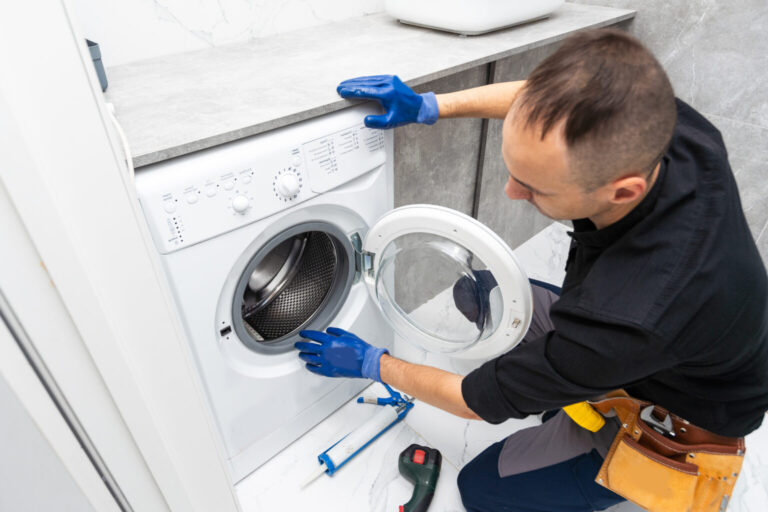 plumber fixing washing machine on white background 2023 12 18 17 29 22 utc 1536x1024 1 768x512