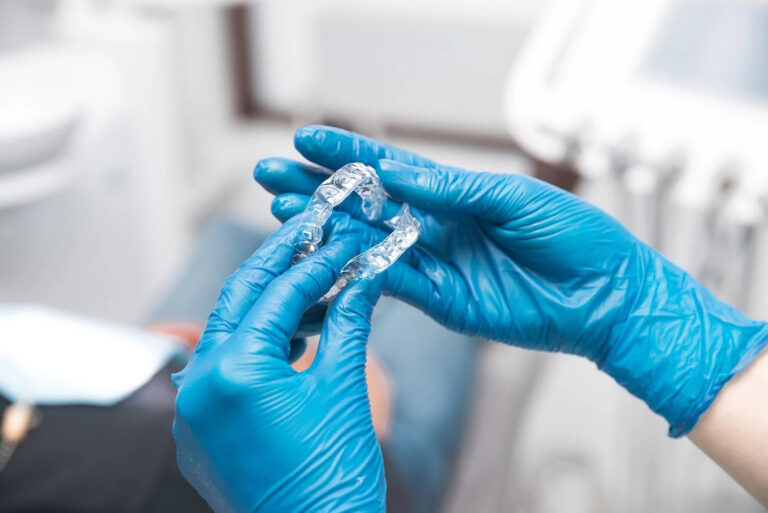 two women hands wearing blue gloves are holding pair invisible aligners shot dental clinic 768x513